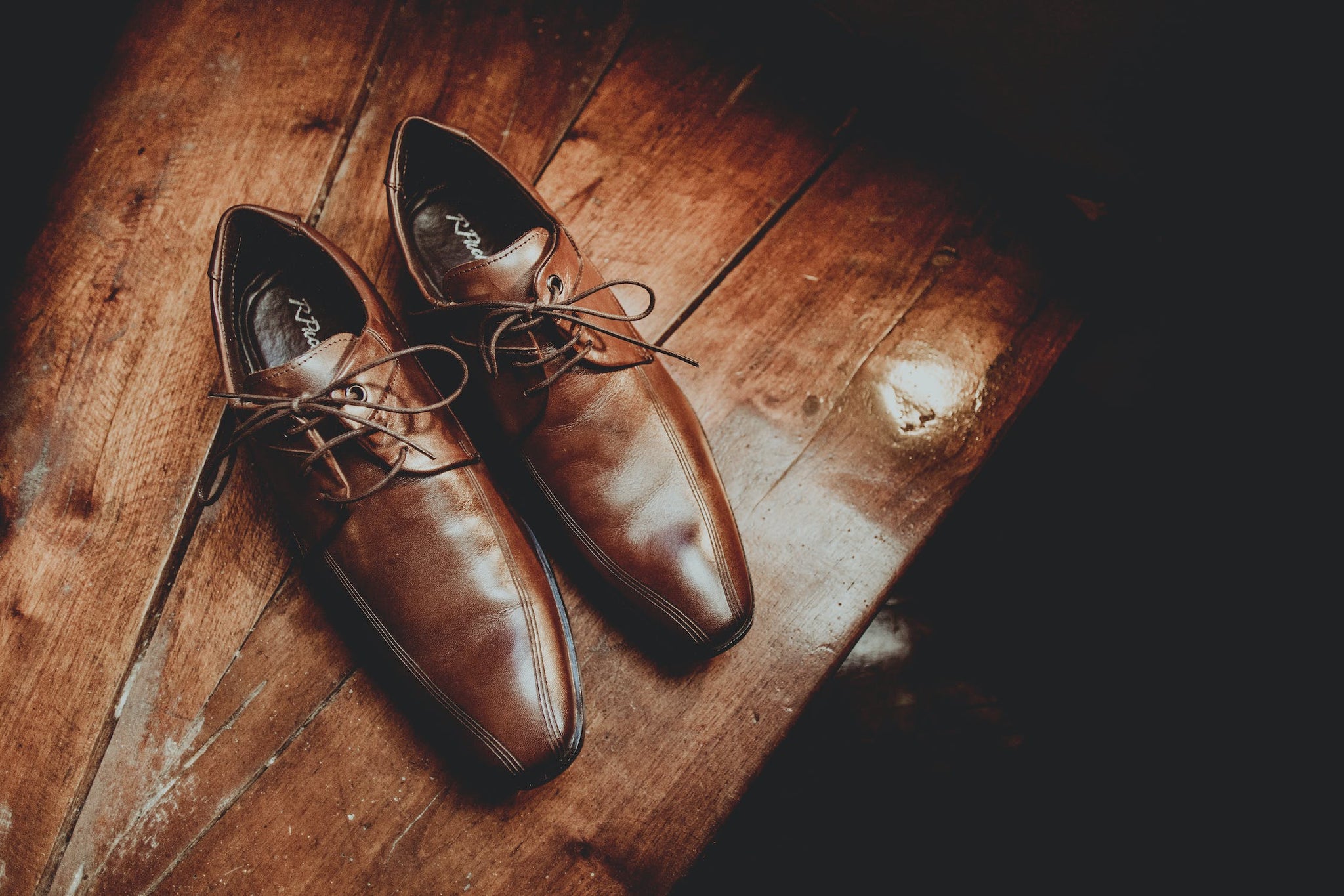 brown leather shoes on wooden surface