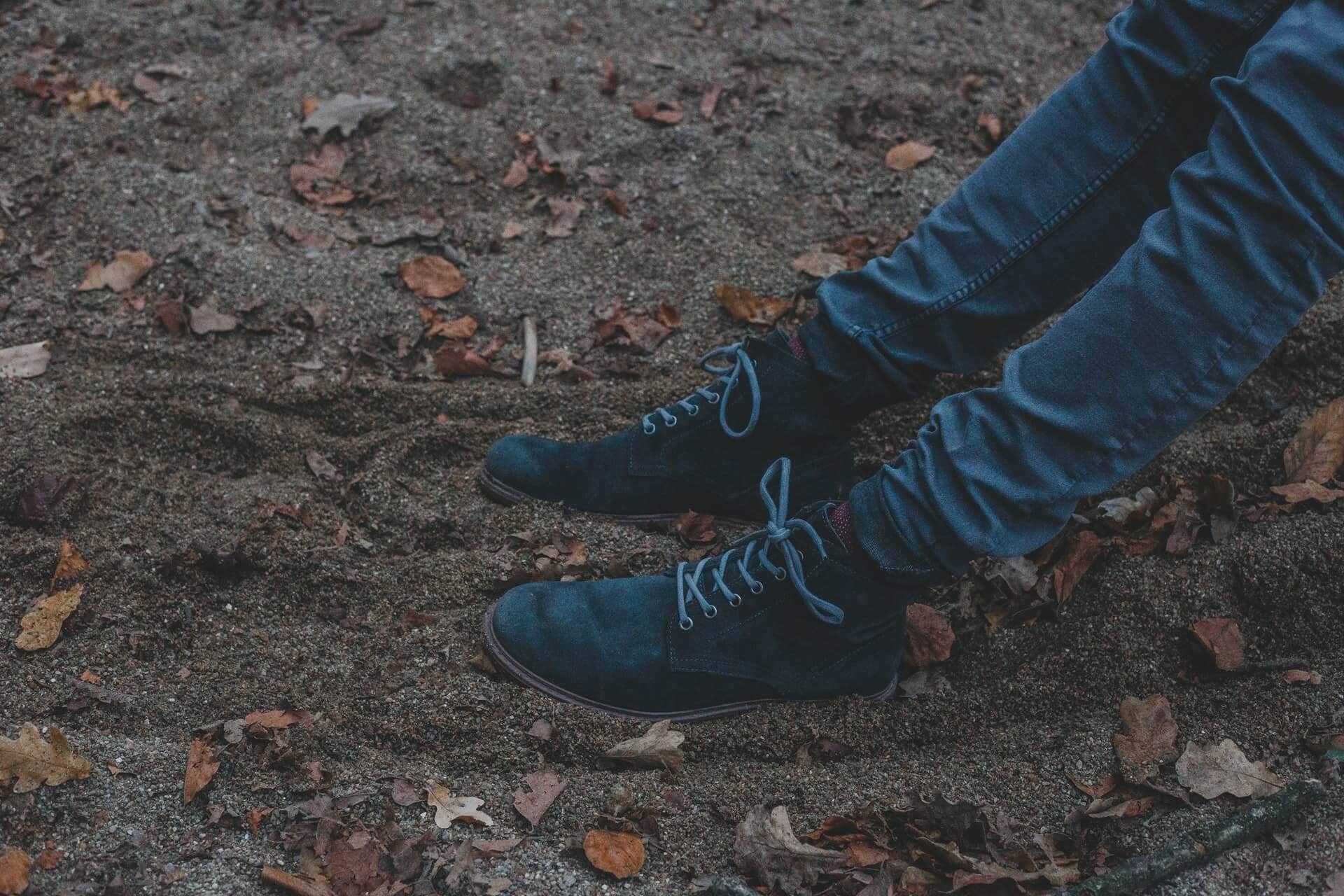 A man’s legs wearing jeans and boots