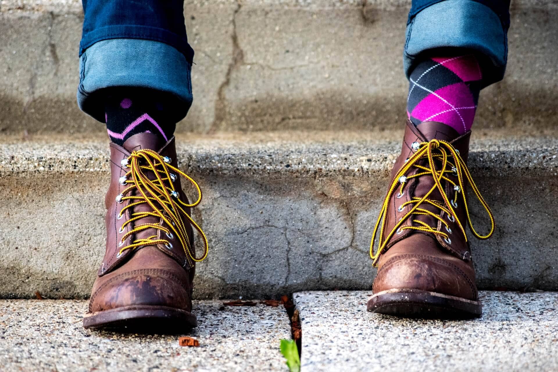 A man wearing purple argyle socks in boots