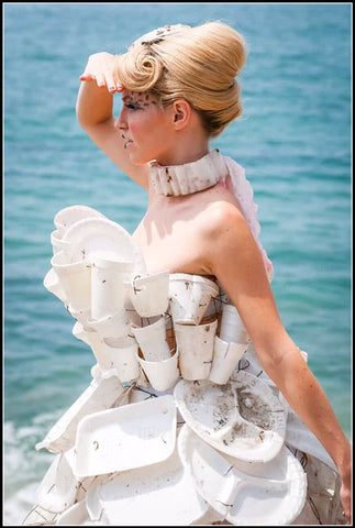 plastic and paper plates and cups waste up cycled into a dress on the beach
