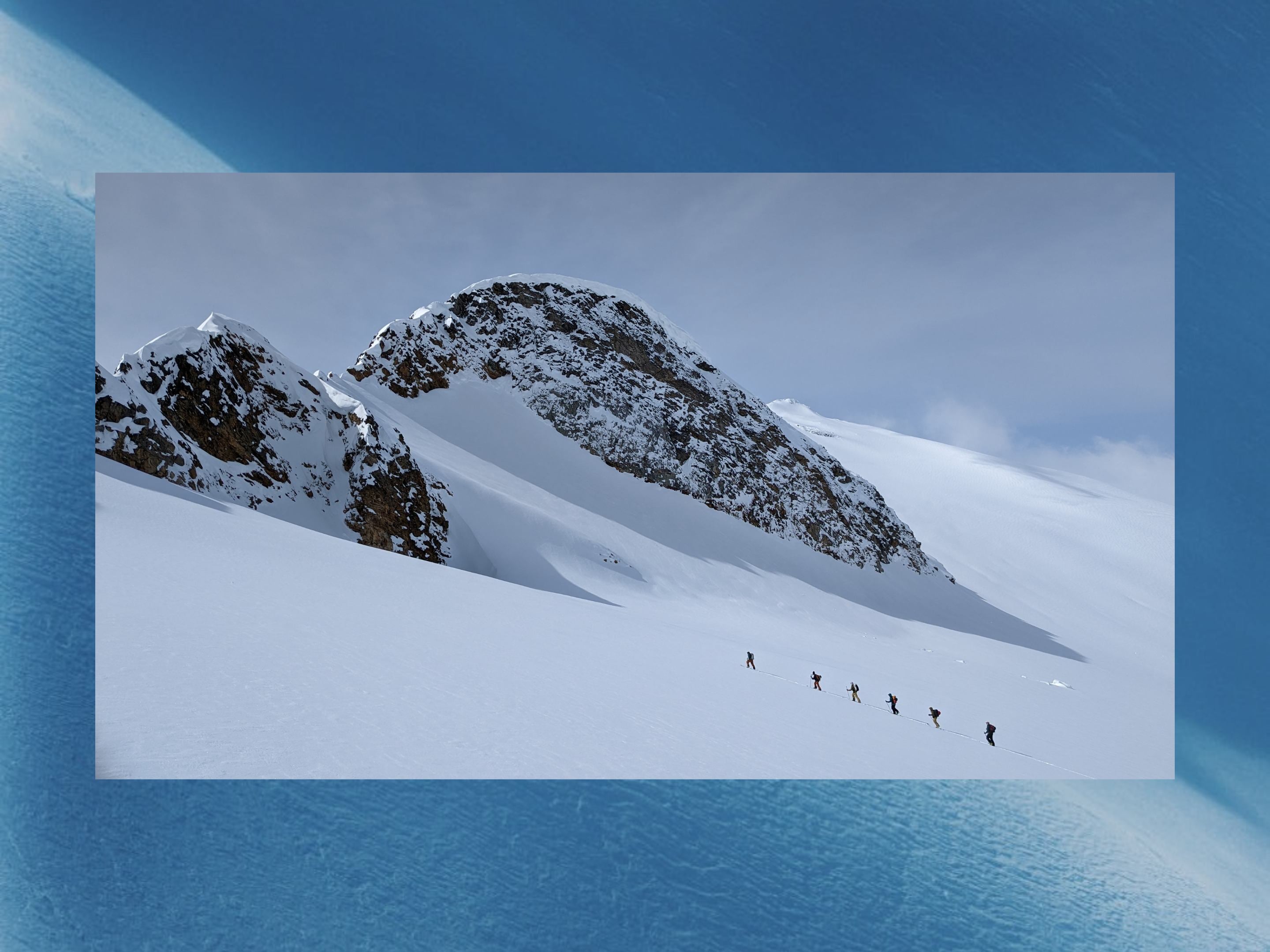 skiers and splitboaders skinning in a vast alpine environment