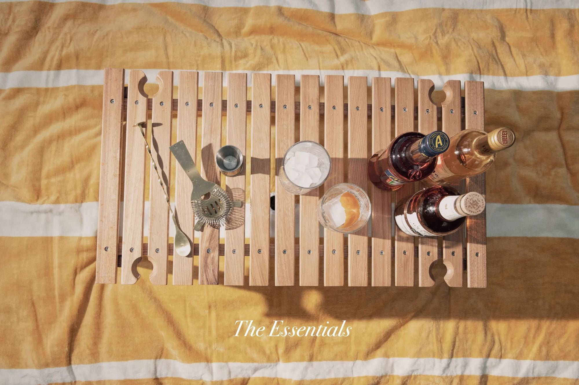 The essentials - a picnic table with whiskey and cocktail ingredients 