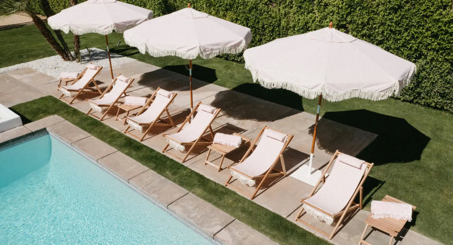 white umbrellas and chairs poolside