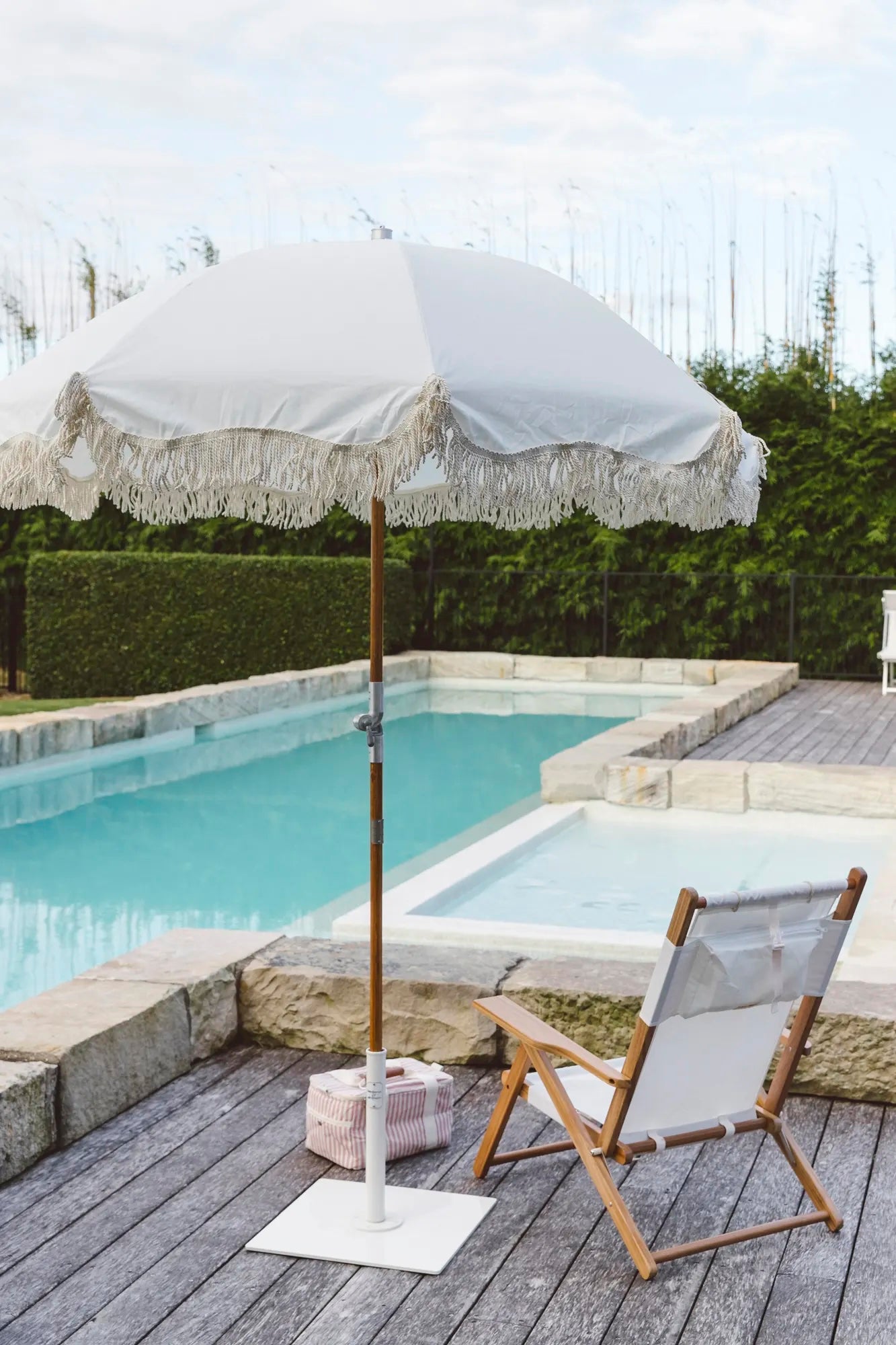 White premium umbrella with a chair and cooler poolside
