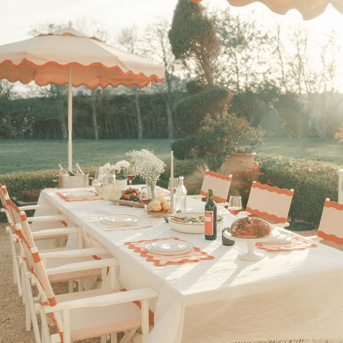 Pink umbrella and table and chairs setup in a backyard