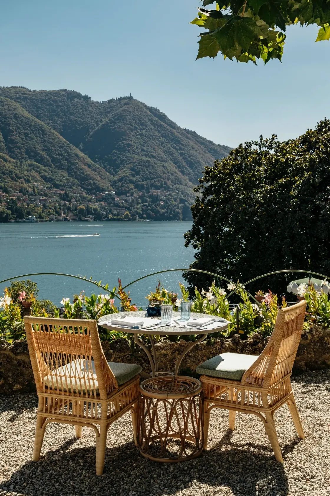 a quaint dining table and two chairs overlooking a lake