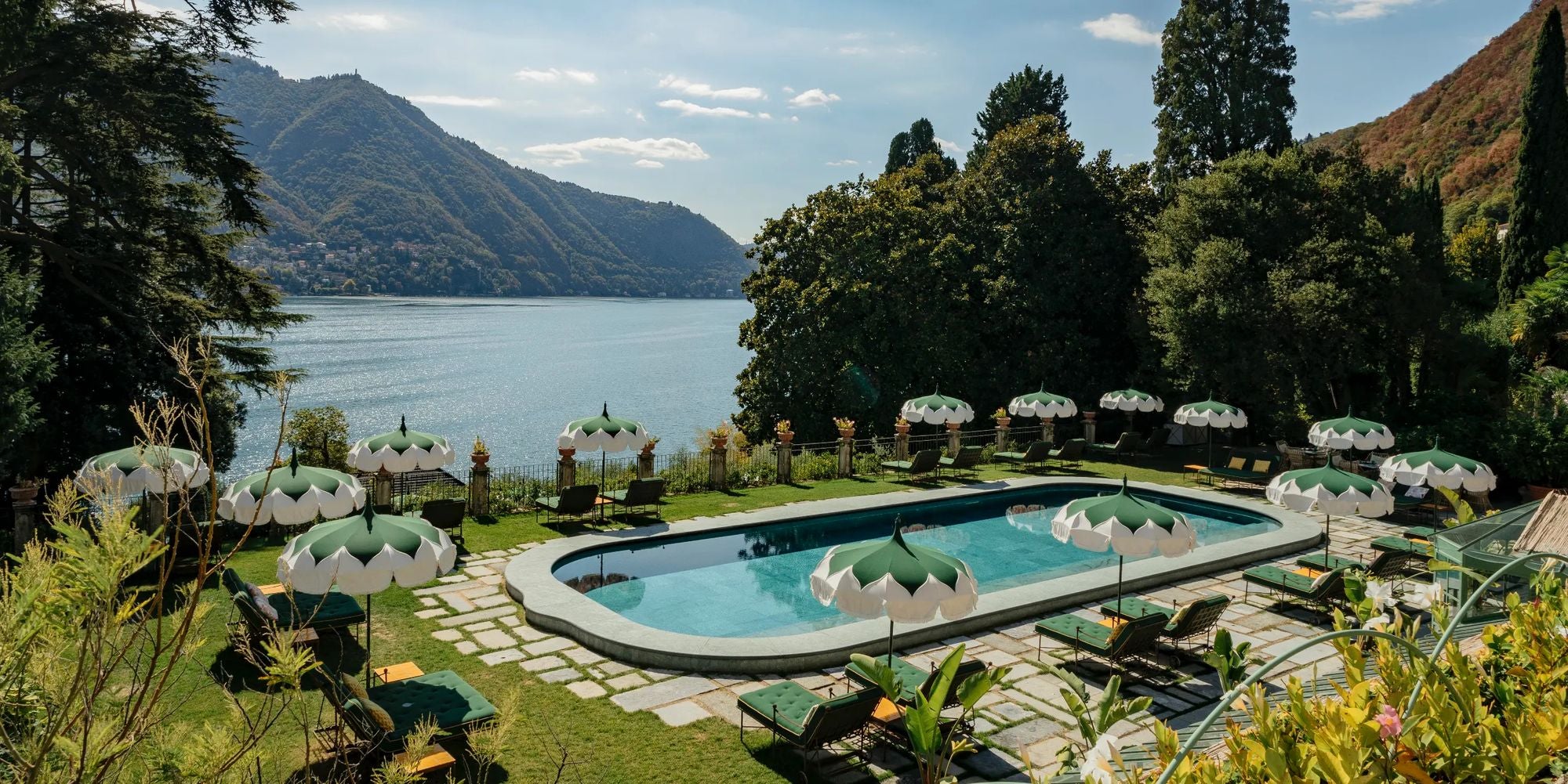 poolside with green umbrellas and a mountain backdrop