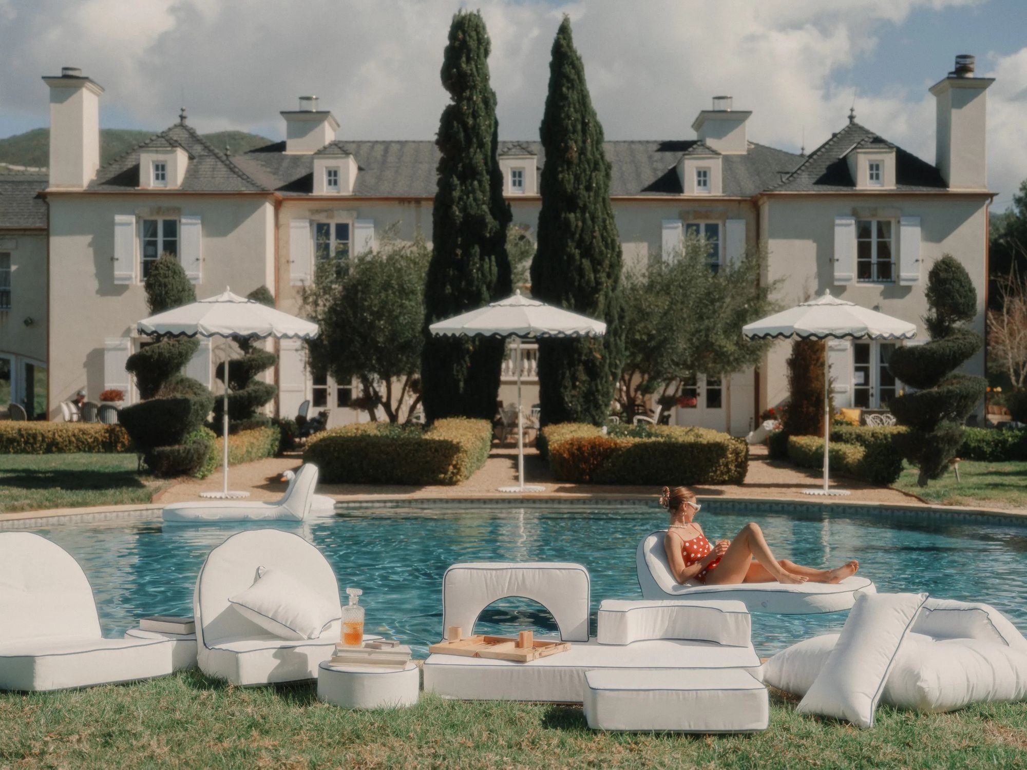 White umbrellas and pool loungers and floats