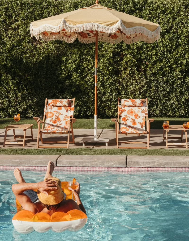 market umbrella and chair with a picnic table by the pool