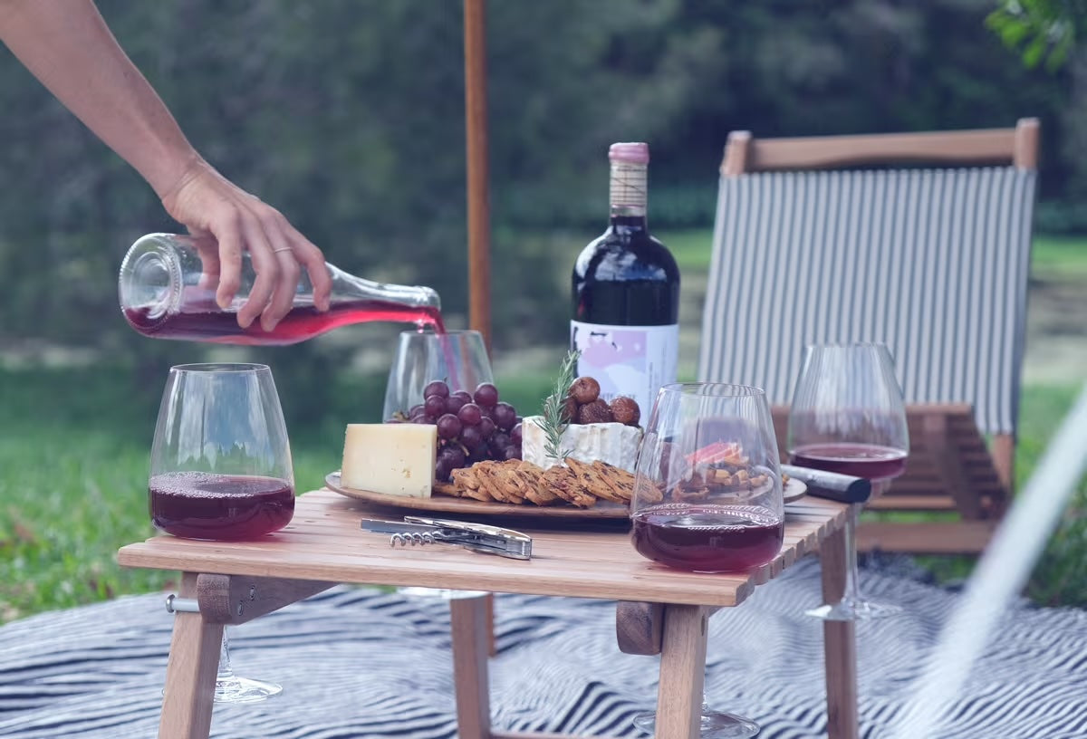 picnic table under a tent with chair and wine