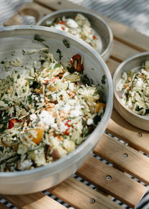 a large and small bowl of salad on a table