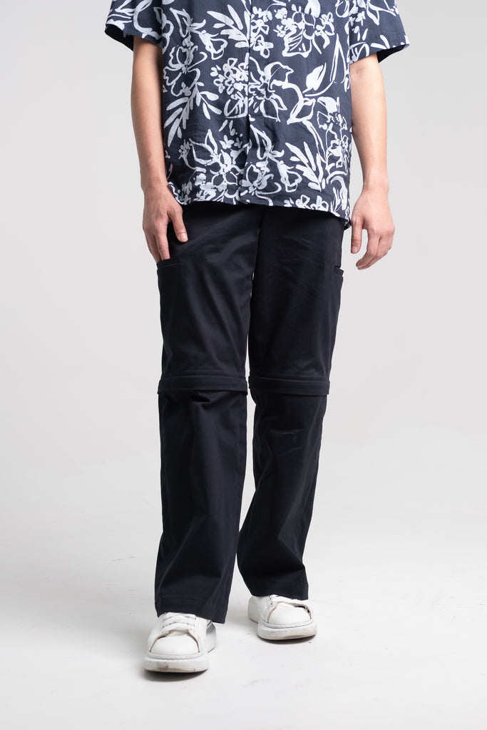 The Convertible Cargo Pants in Black, being worn as its long pants version.