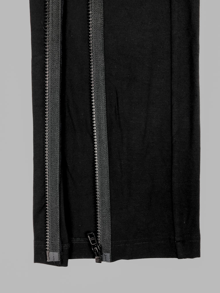 Close up of the bottom of customised pants in black. Parallel FrontSlit opening on both sidesallow pants to open fully.