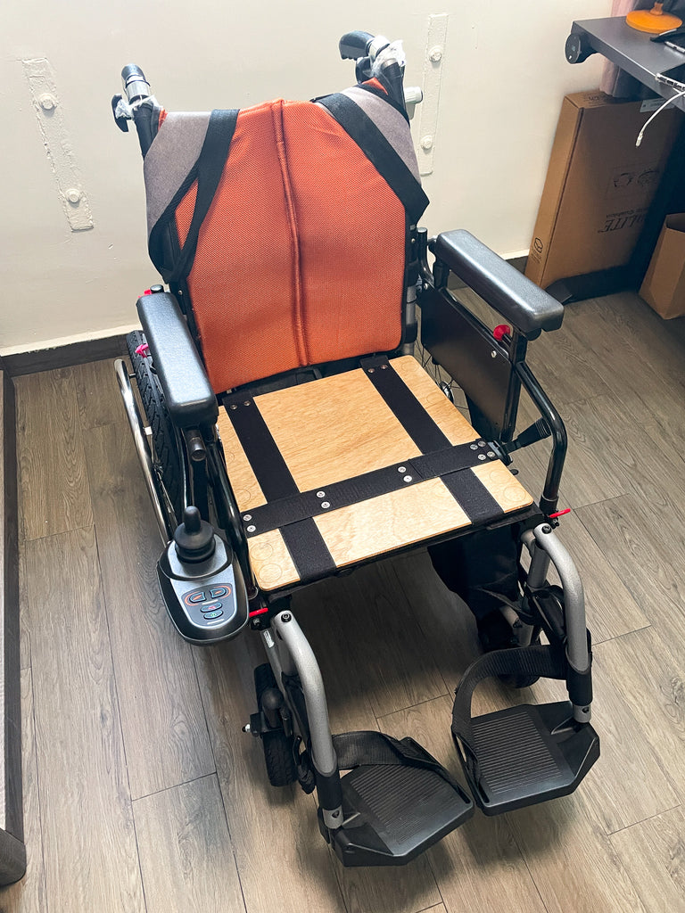 Wheelchair fitted with the new custom-made wooden board.