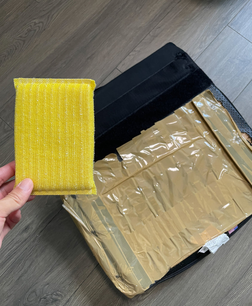 Dishwashing sponge (yellow) used to prevent the wheelchair seat cushion from moving around.