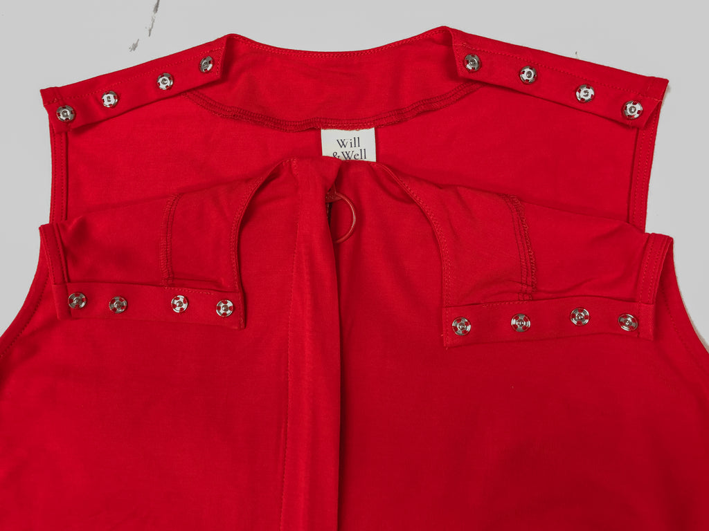 Close up of the customised Sleeveless Blouse in bright red. Snap buttons on the shoulders to facilitate easy dressing processes.