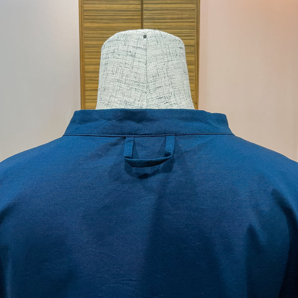 a close-up shot of the back of a navy blue shirt with a loop at the bottom of the collar.