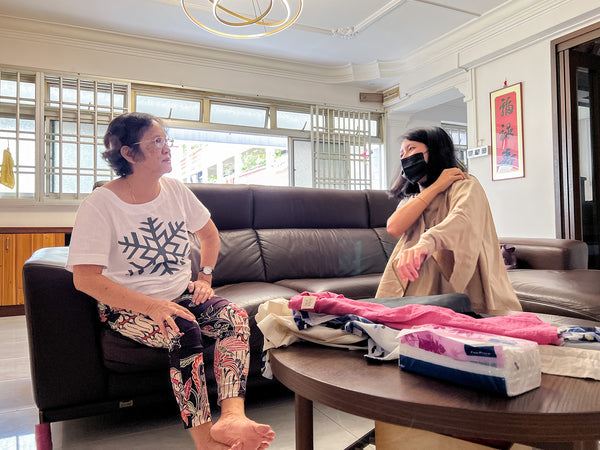 Elisa demonstrating the customised blouse to Jane's mother