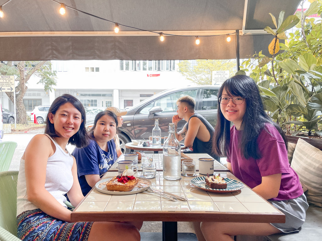Elisa, Madalene, and Janessa having brunch together at a cafe.