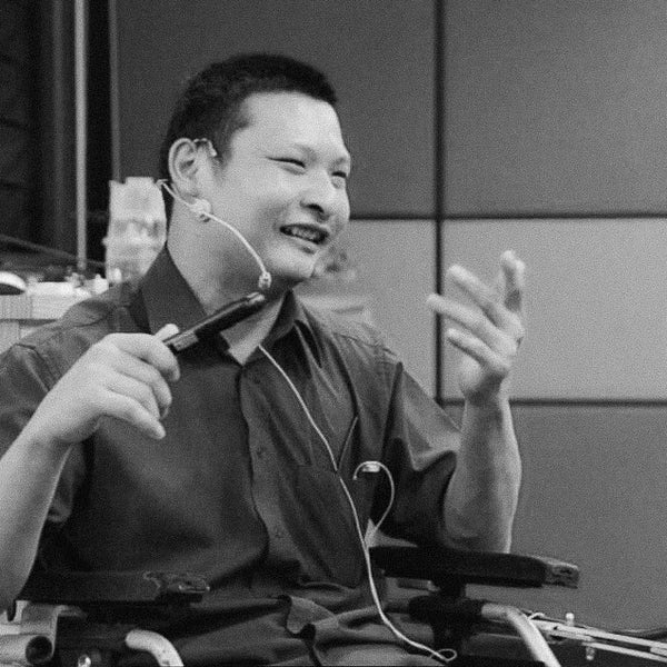 a black and white image of Kang Wei giving a presentation