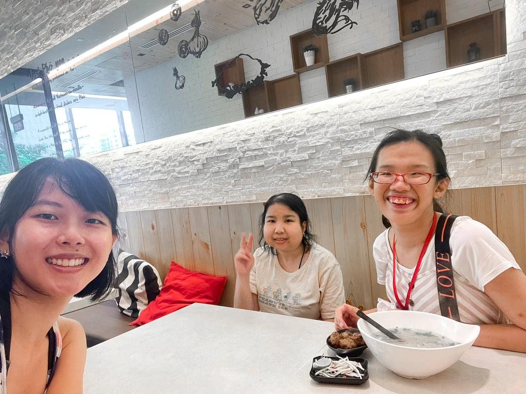 A group selfie of Elisa and two female craftsmen having a meal together.