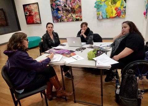 Access Committee sits around a table at a meeting. 