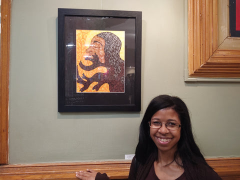 donchellee fulwood stands in front of one of her paintings