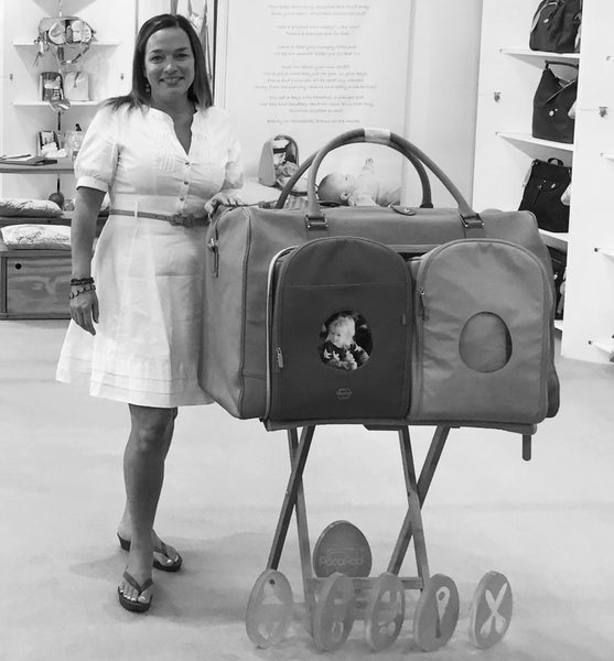 PacaPod Founder Jacqueline waggett at a trade show in front of a giant changing bag prop