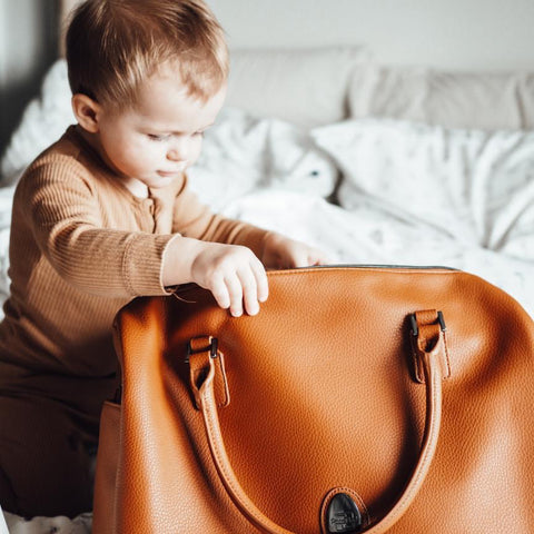 baby looking into tan coloured firenze bag