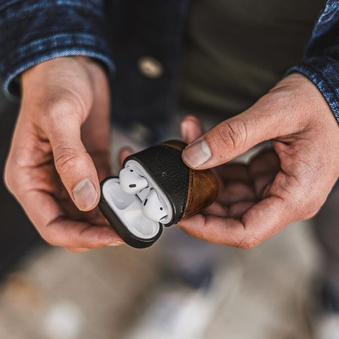 A man holding the Bullstrap leather AirPods case.