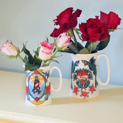 Two bone china jugs from our Sailor's Story collection showcasing a striking lighthouse inspired by sailor's tattoos. Luxury and absolutely unique homewares.