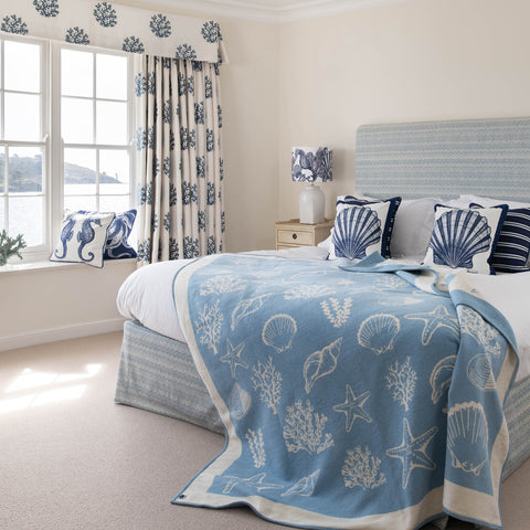 Woollen shell throw in light blue with scallop cushions