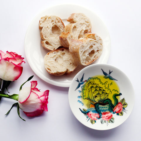 A bone china nibbles dish from our Sailor's Story collection showcasing a tall shop and swallows inspired by sailor's tattoos. Luxury and absolutely unique homewares.