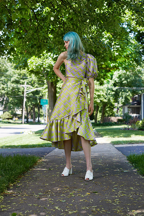 Cynthia Rowley Resort 2019 Collection features a pastel purple and green chevron set with a mid length wrap skirt and a one sleeve cropped top.