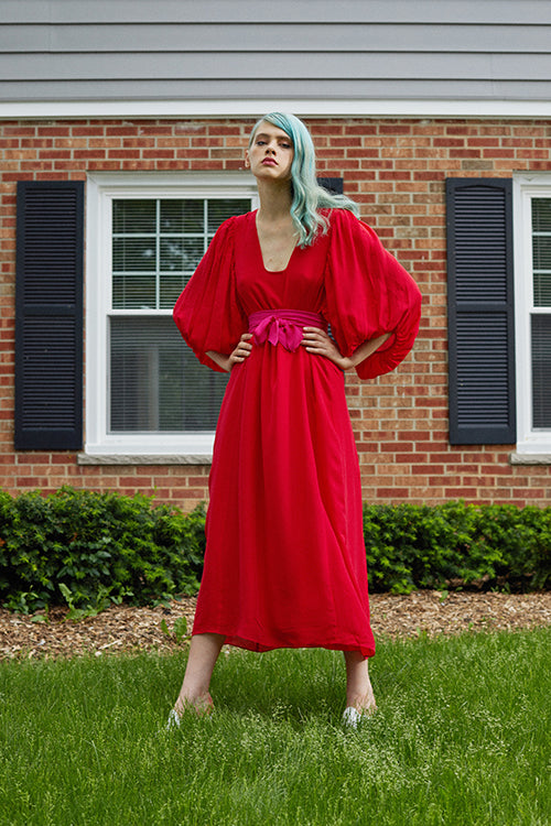 Cynthia Rowley Resort 2019 Collection features a red dress belted at the high waist, flowing into a maxi length skirt. 