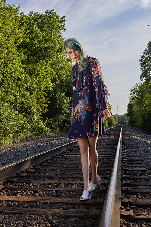 CR resort 2019 collection features a navy floral mini dress with feminine ruffles, coupled with white chunky heels. 