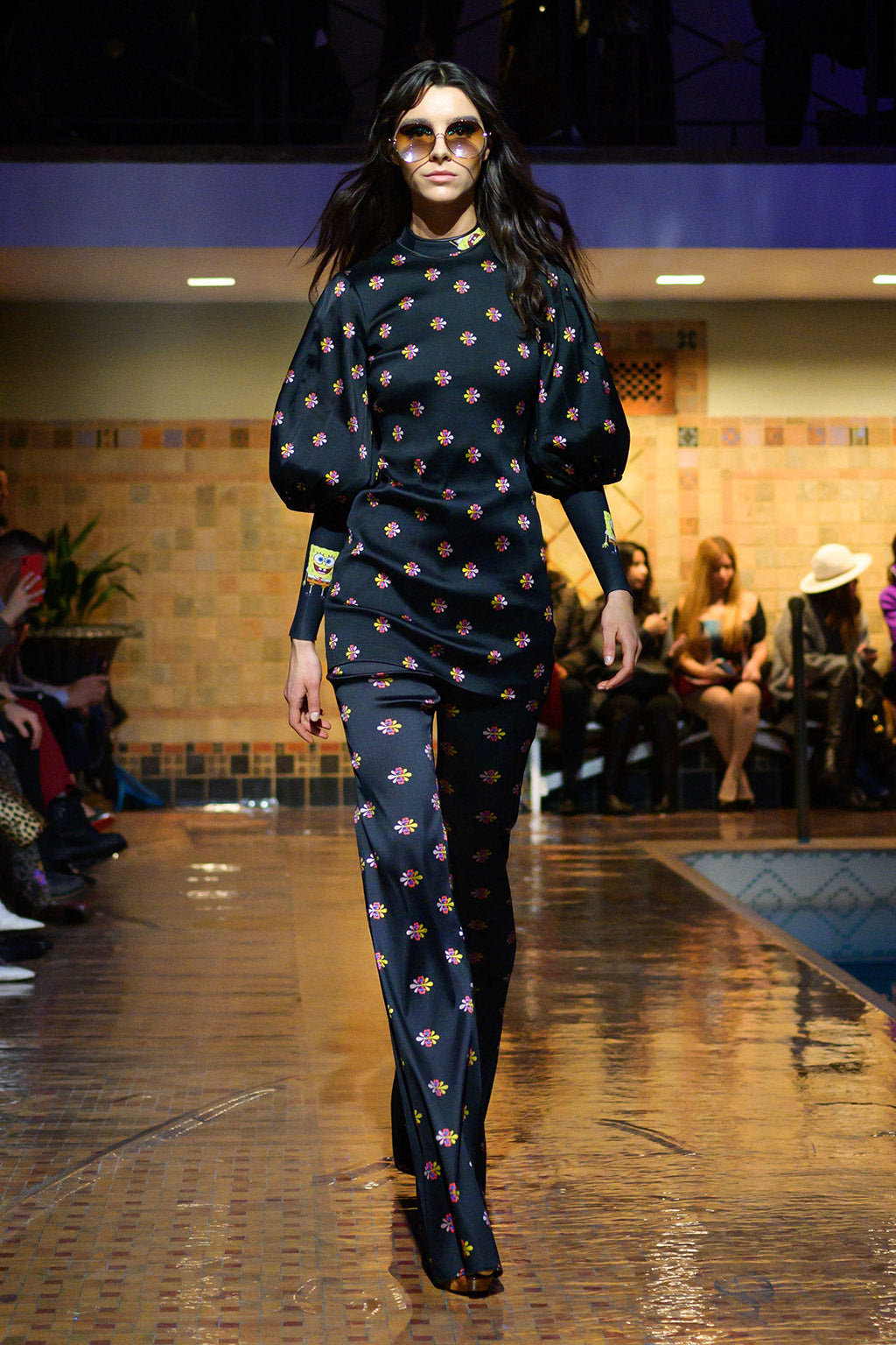 Cynthia Rowley Fall 2019 look 4 featuring a blouse in floral print with elbow length sleeves worn over a SpongeBob print Wetsuit, and pants in floral print