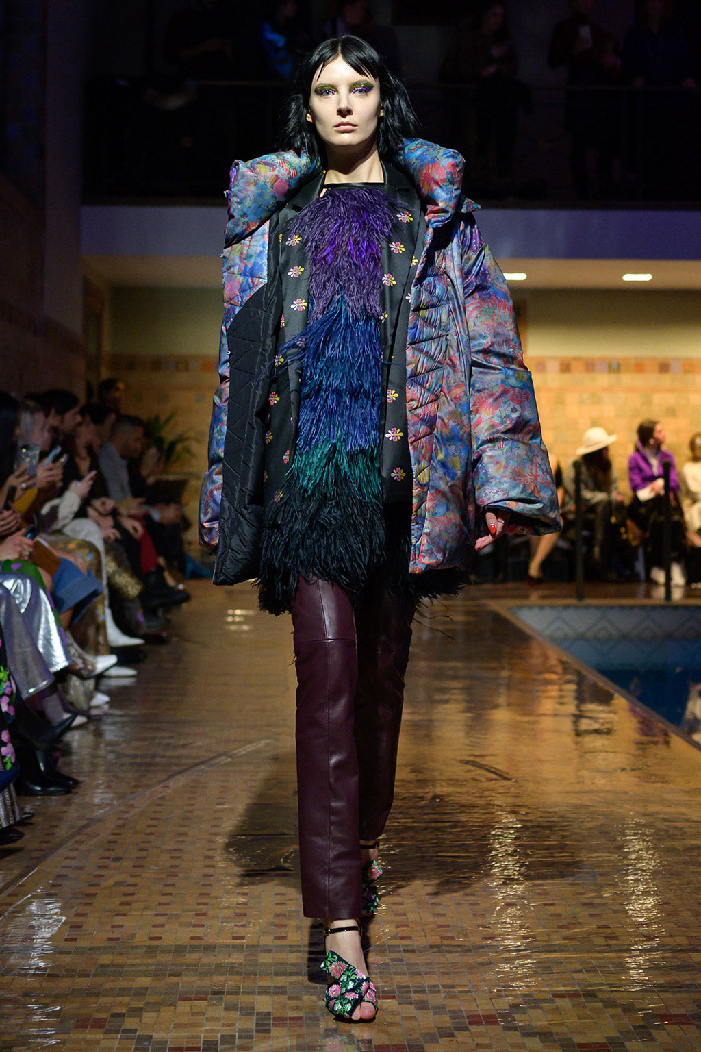 Cynthia Rowley Fall 2019 look 5 featuring a mini dress with multi-colored feathers, wine red leather pants, and puffer jacket with multi-color print