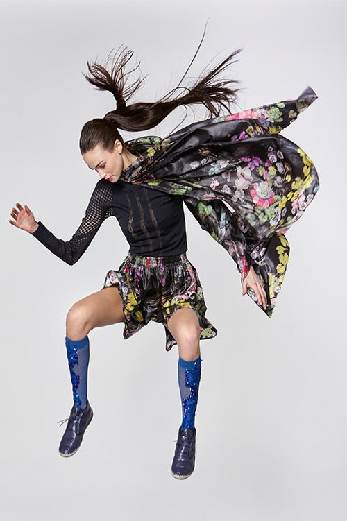 Cynthia Rowley Fall Fitness 2015 look 2 featuring dark floral print shorts and poncho, and black stretch long sleeve shirt with sheer cut outs
