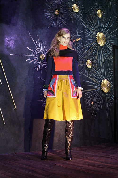 Cynthia Rowley Fall 2014 look 28 featuring a orange navy and dark blue long sleeved shirt with color blocking details on shoulders turtleneck and front with yellow knee length shorts with orange white blue and purple appliques on sides