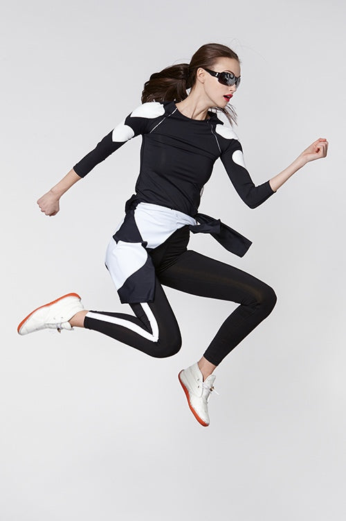 Cynthia Rowley Fall Fitness 2015 look 13 featuring black leggings with white stripe and black long seen top with white hearts and color block wind breaker jacket ties around waist