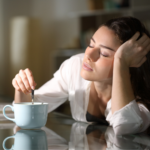 Tired pregnant lady trying to stay awake making a cup of tea