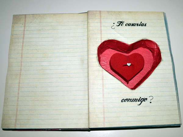 Book Engagement Box A hollowed out notepad, with a heart shaped hole decorated red and containing an engagement ring