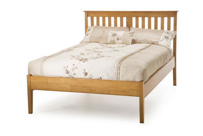 Wooden bed frame with double mattress and cream bedding