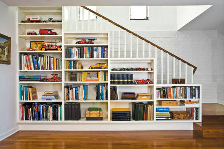 built-in-x Tiered white shelving stood against the side of a staircase