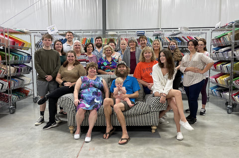 The whole MFQS team in our warehouse of fabric