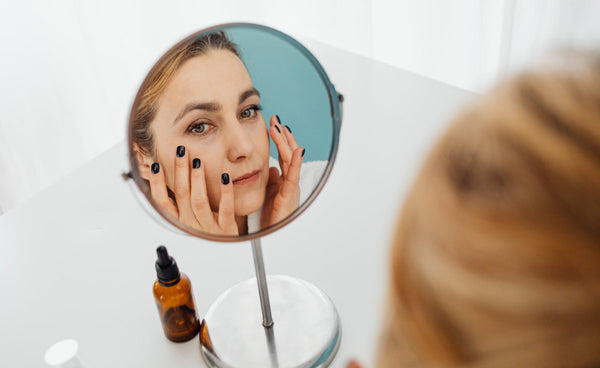Woman Looking For Fine Lines In Mirror