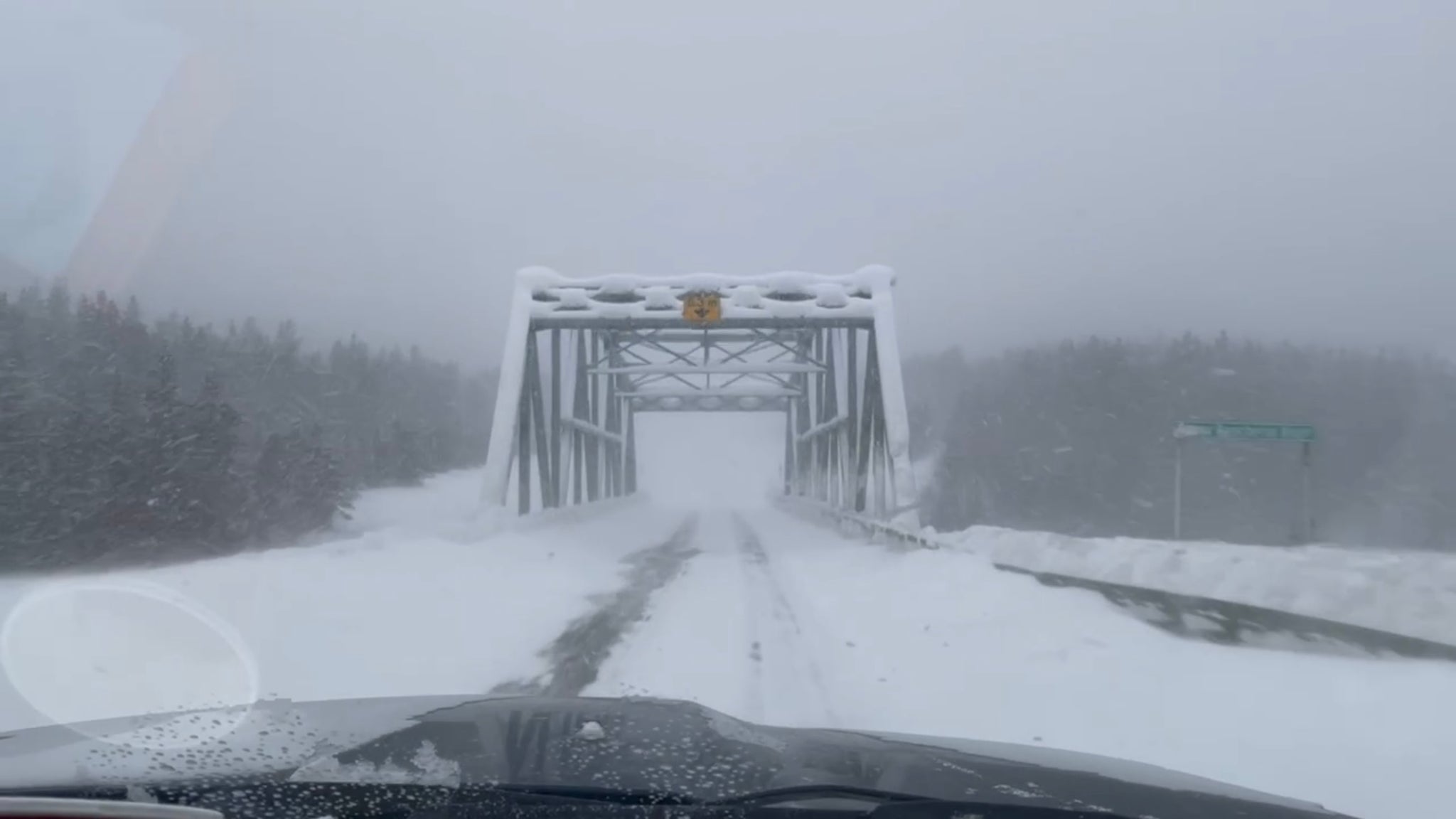 Snow covered Yukon scenery and metal truss bridge