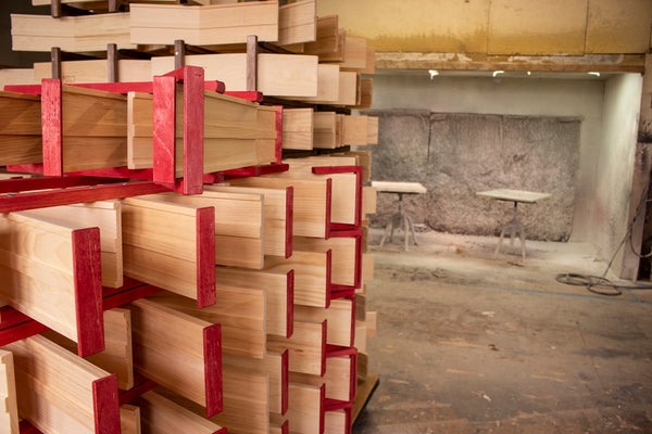 A rack of cart tracks dries in front of the paint booth