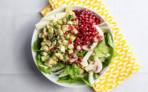 Close up of egg salad over romaine with mushrooms and pomegranate seeds.